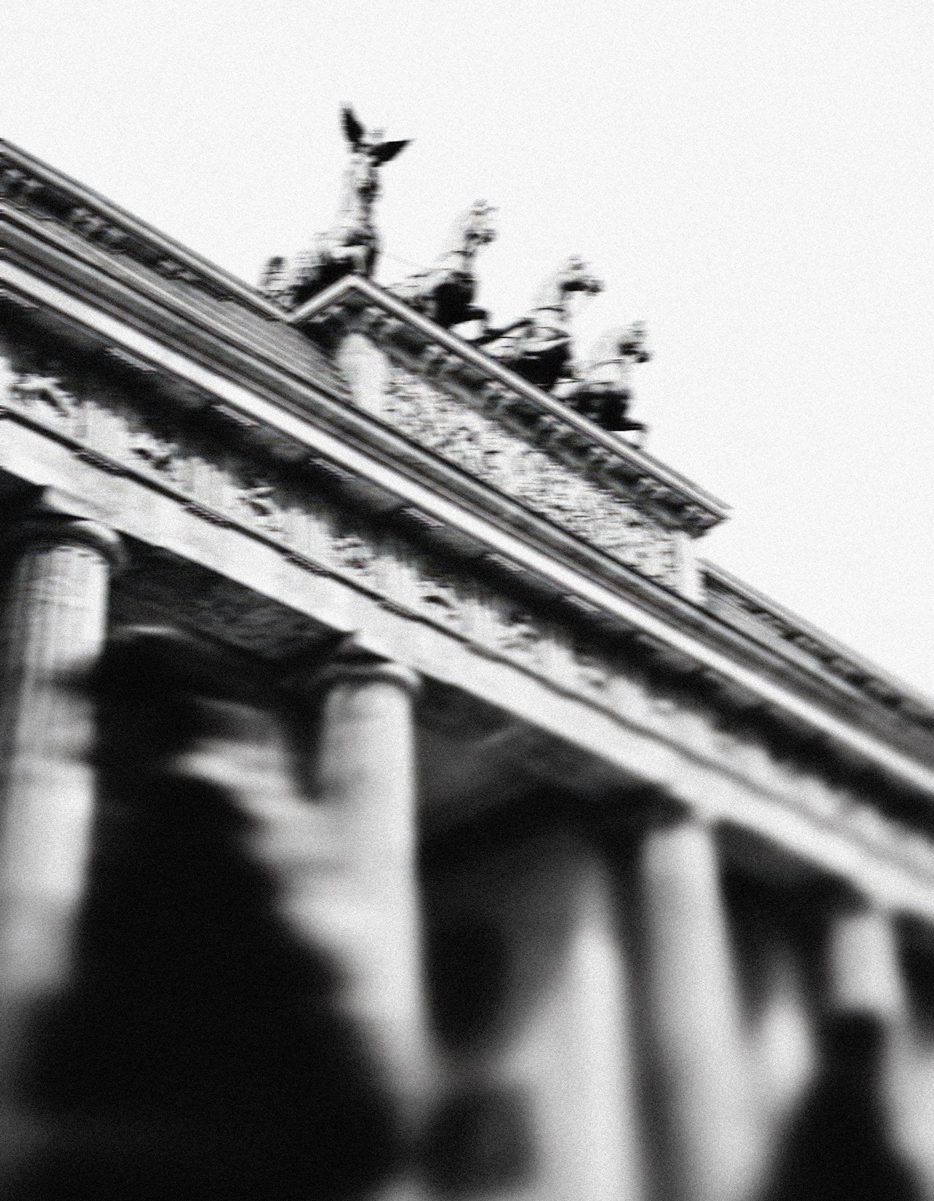 The Brandenburg Gate seen from below, with passers-by blurred in motion