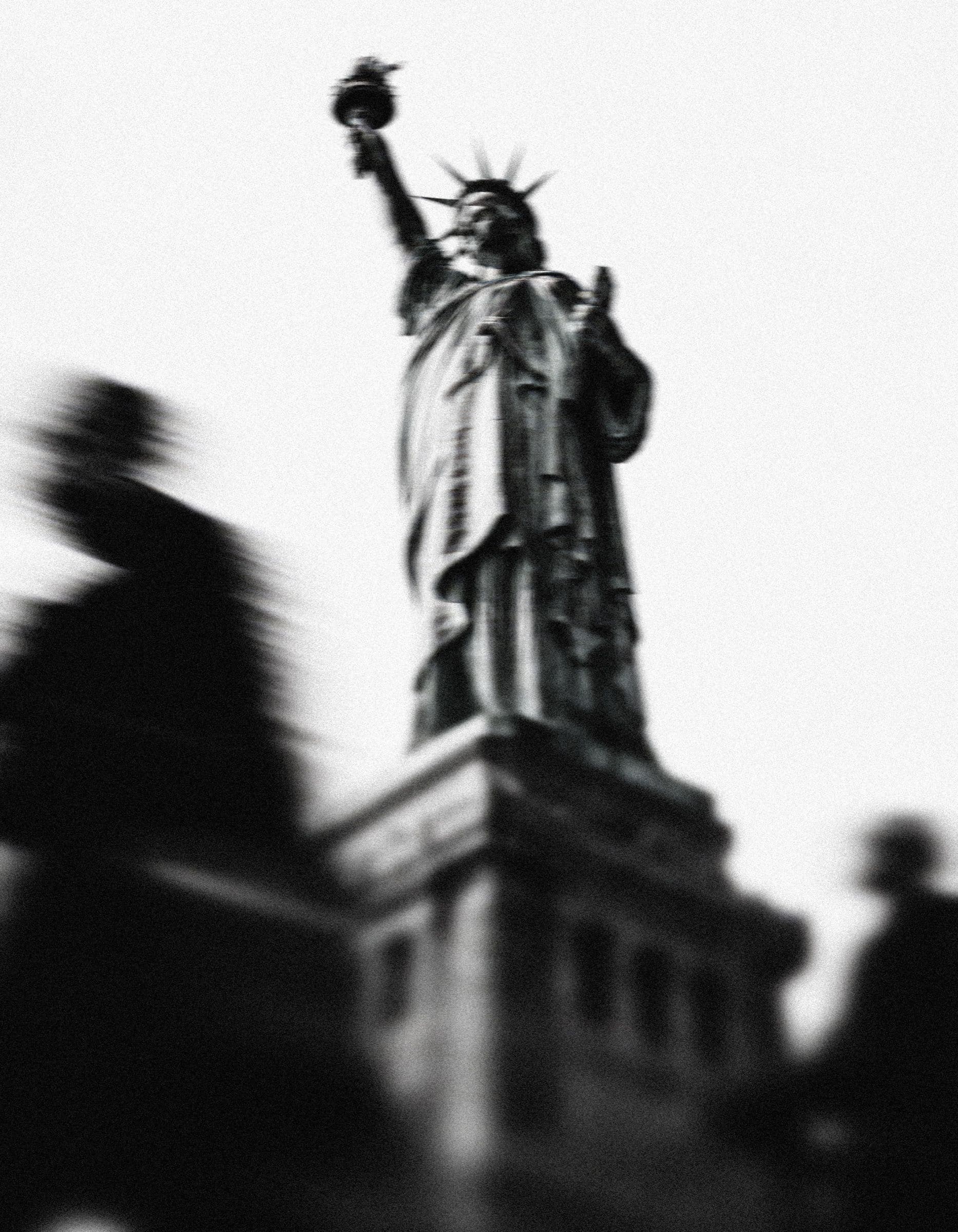 The Statue of Liberty, with passers-by blurred in motion