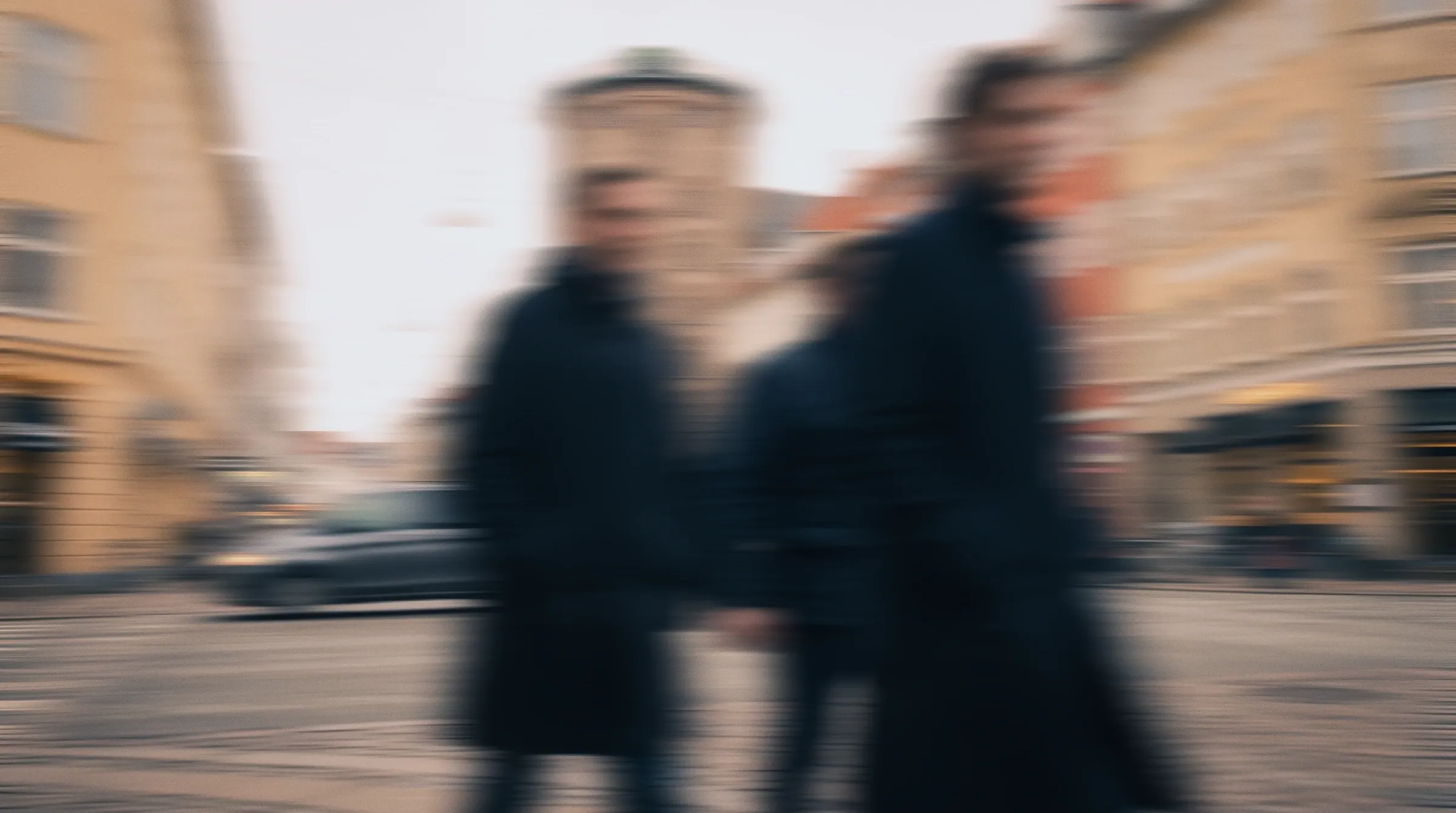 Commuters walking along a Copenhagen street, blurred in motion