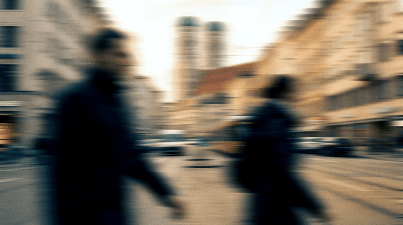 Commuters crossing a Munich street below the Frauenkirche towers